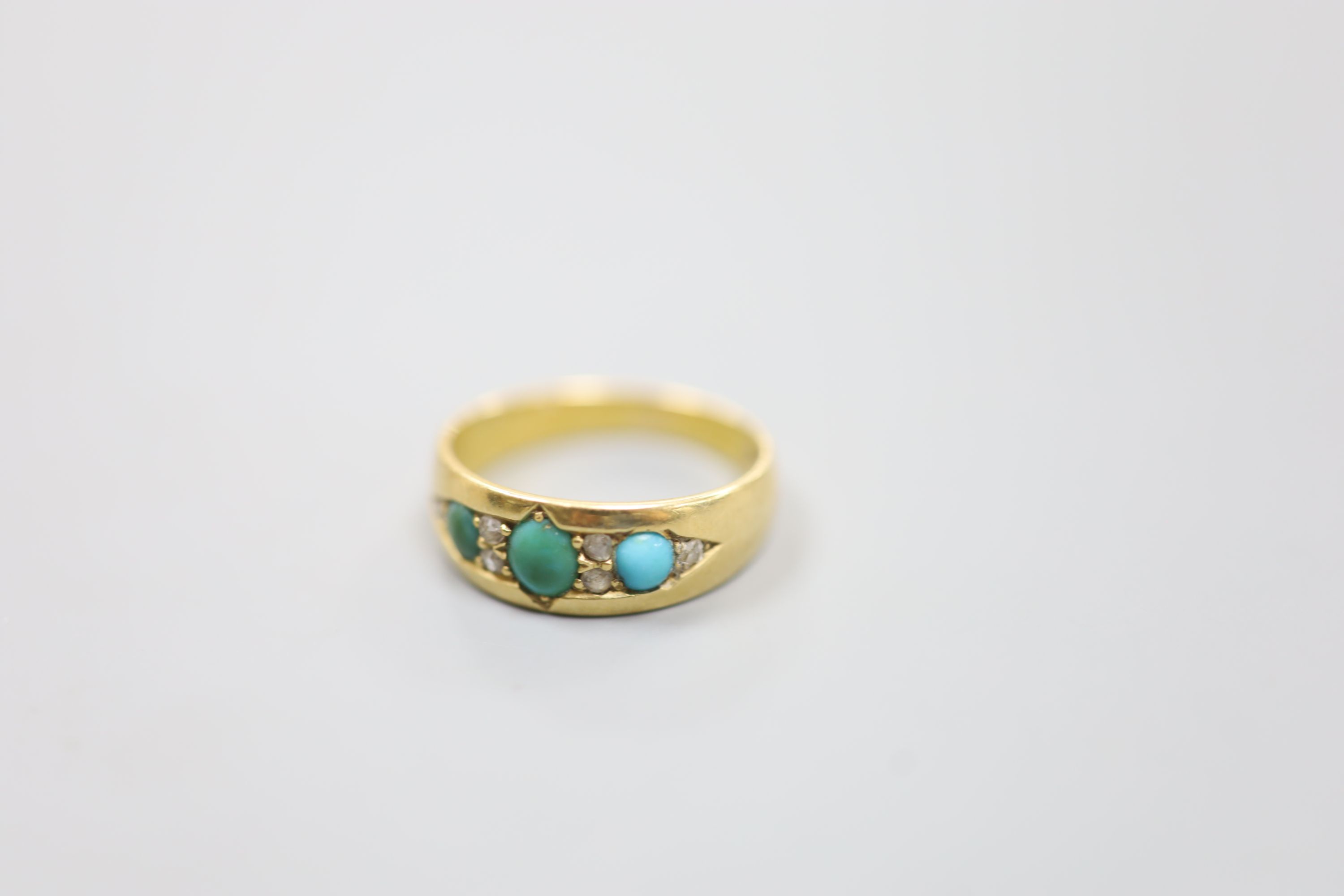 An early 20th century 18ct, three stone turquoise and six stone diamond chip set ring, size M/N, gross 4 grams.